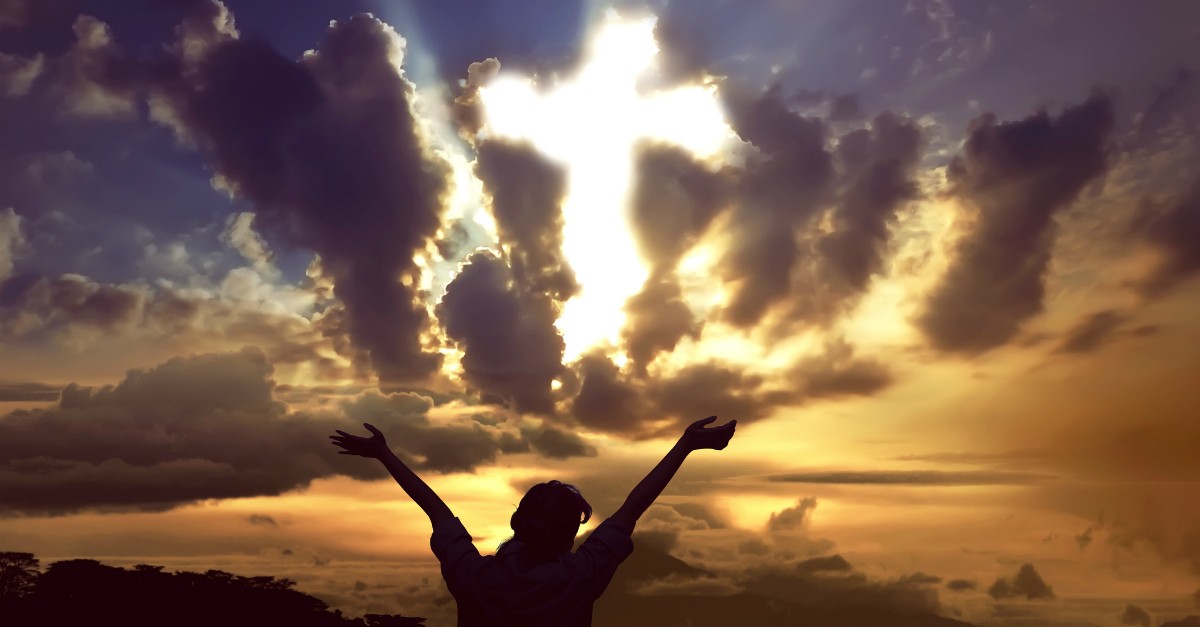 cross appearing in sunset sky woman praising Jesus is risen Easter