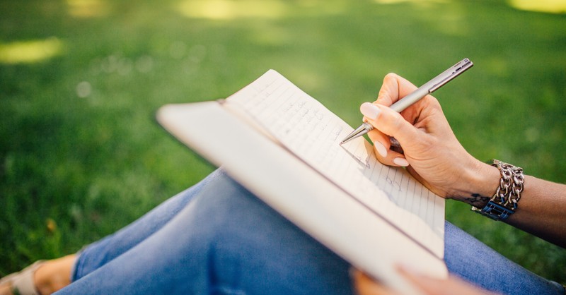 woman outdoors writing in journal, christian fiction authors