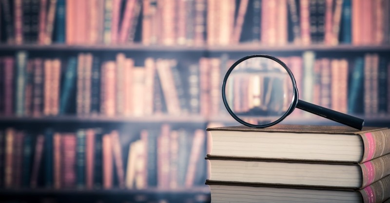 magnifying glass on book pile, mystery authors christian fiction authors