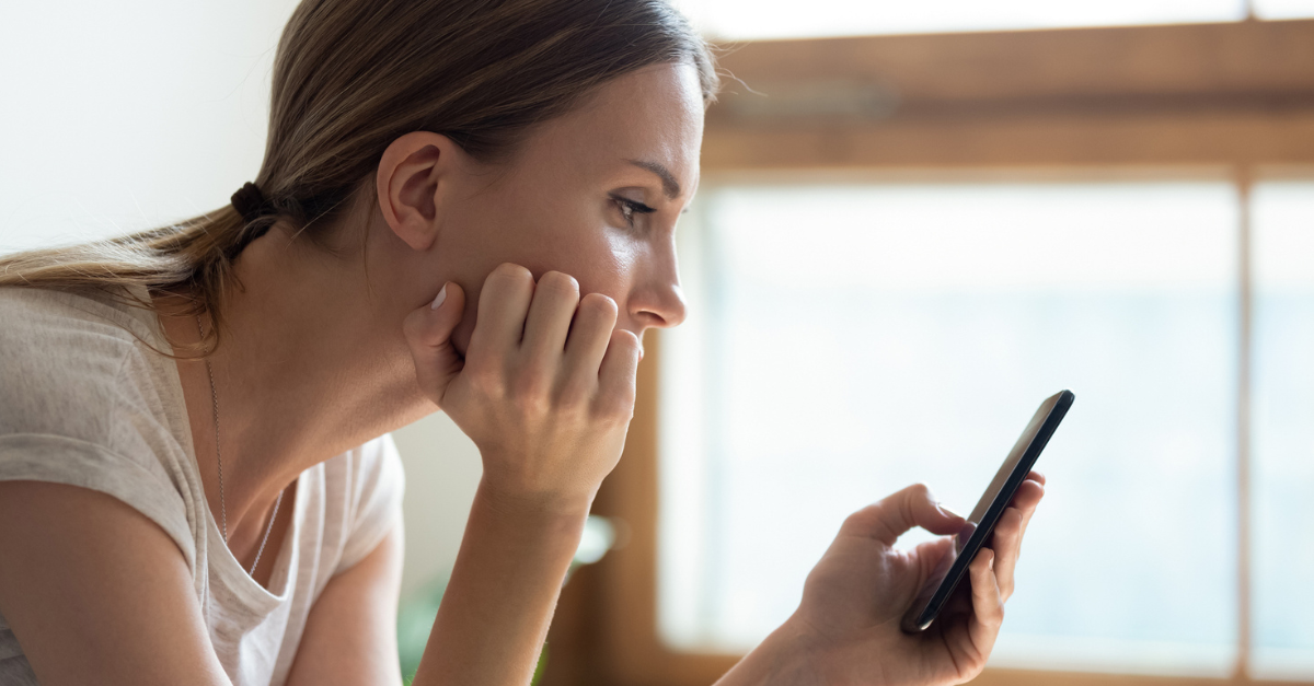 Woman staring at her phone; strategies to resist comparison.